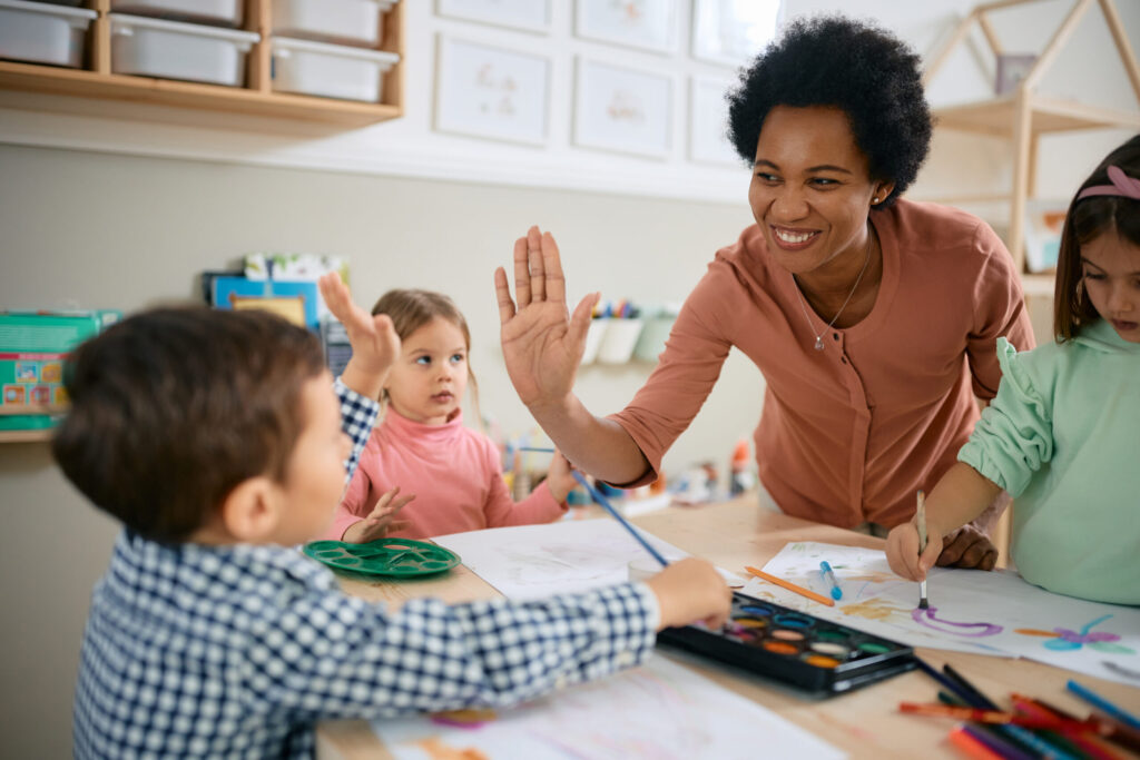 teacher high-fiving students in classroom