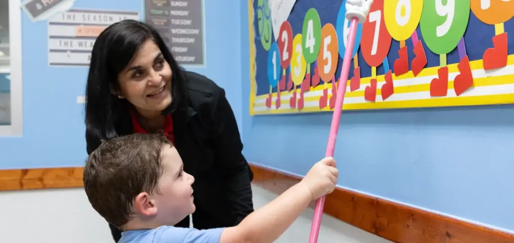 a boy with his teacher reading numbers